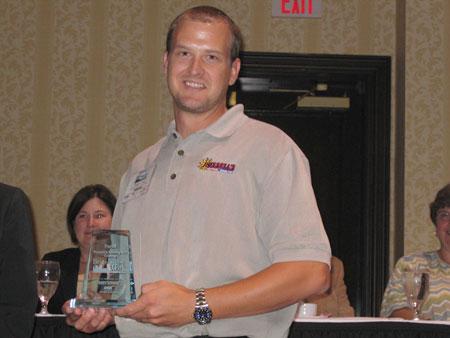 Russell's team member accepting glass award