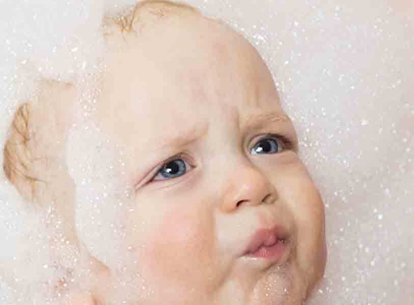Unsure baby surrounded by many bubbles