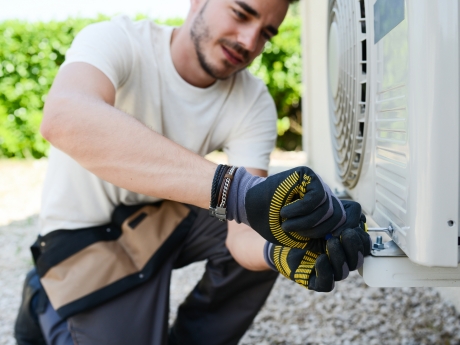 man fixing an air conditioner unit
