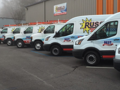 Fleet of Russell's Heating & Cooling of Chesapeake, VA service vans outside Russell's building