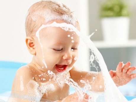 Baby splashing in soap bubbles