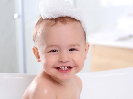 Smiling baby with soap on top of head