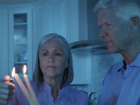 Elderly couple lighting candles in the dark